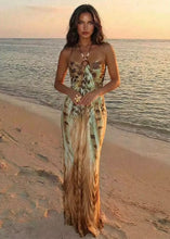 Cargar imagen en el visor de la galería, Calypso boho tropical print halter maxi dress styled on a beach
